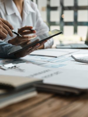 Asian business adviser meeting to analyze and discuss the situation on the financial report in the meeting room.Investment Consultant,Financial Consultant,Financial advisor and accounting concept.